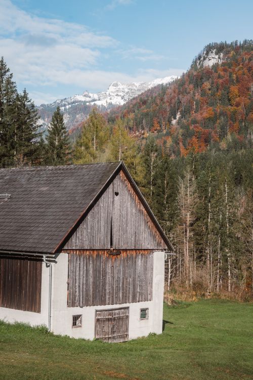 Free A charming wooden barn set against a backdrop of colorful autumn foliage in the Alps. Stock Photo