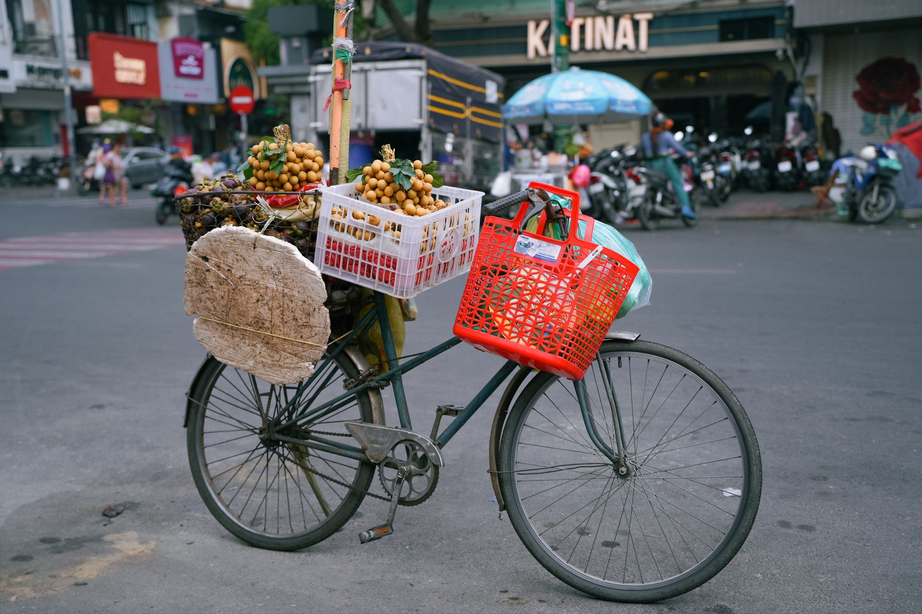 A bicycle loaded with fruits and goods in a busy street, symbolizing urban life and commerce.