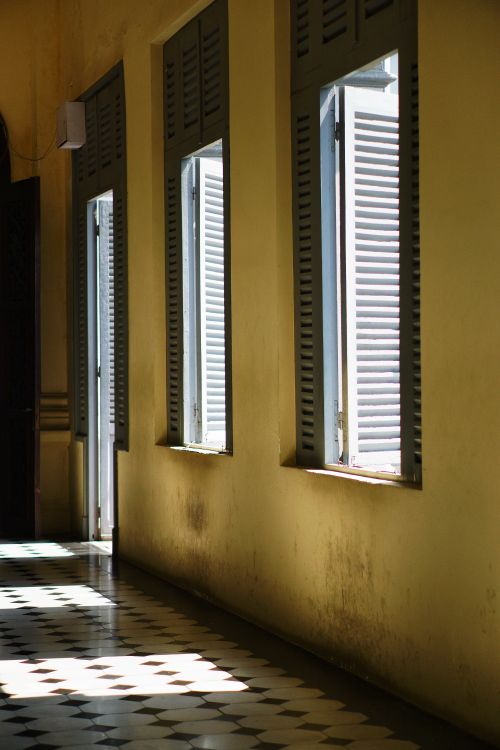 Free Elegant vintage corridor with sunlight streaming through open shutters in Ho Chi Minh City, Vietnam. Stock Photo