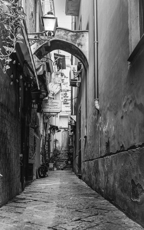 Free Explore a narrow European alleyway captured in black and white, evoking a classic urban charm. Stock Photo