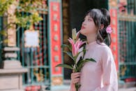 Young Woman Holding Lily in Traditional Dress