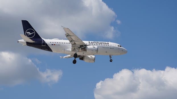 A Lufthansa jet cruising through blue skies above Hamburg, Germany.