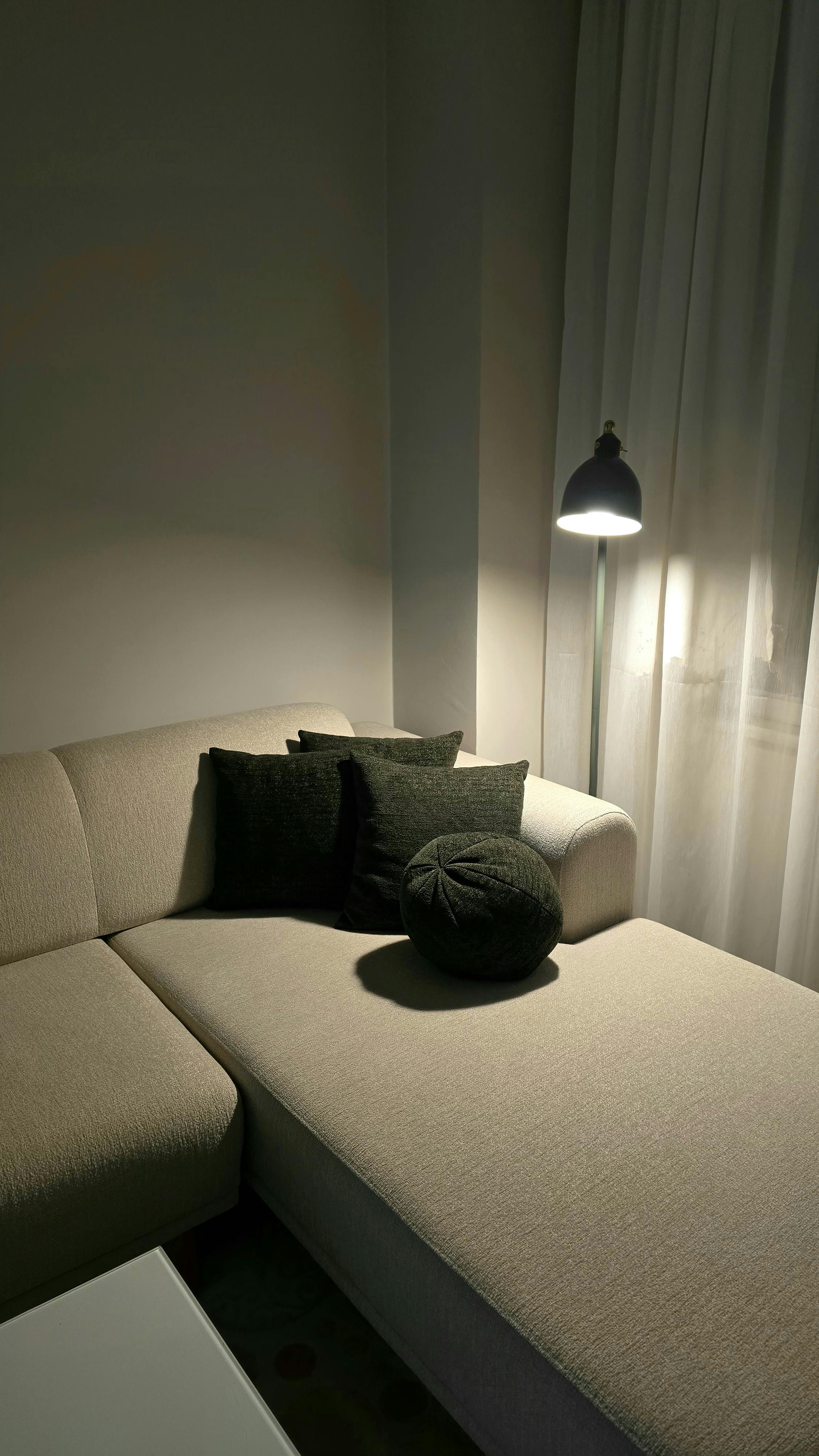 A serene living room corner with soft lighting and comfortable cushions, perfect for relaxation.