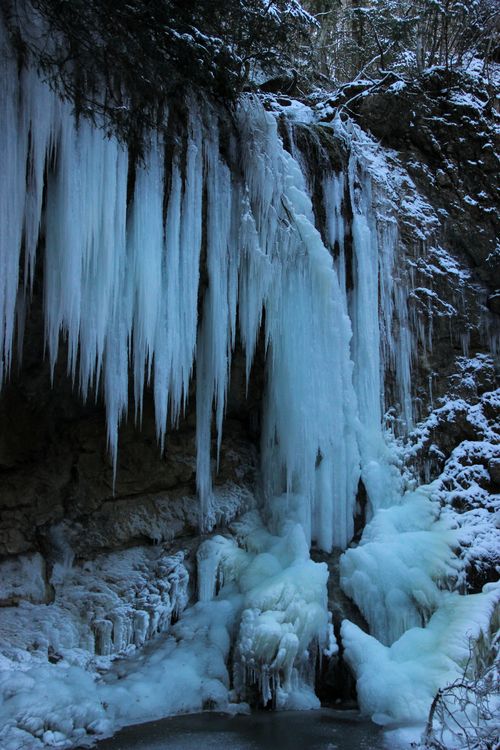 Free Close-up of majestic icicles and frozen waterfall in a snowy forest. Stock Photo