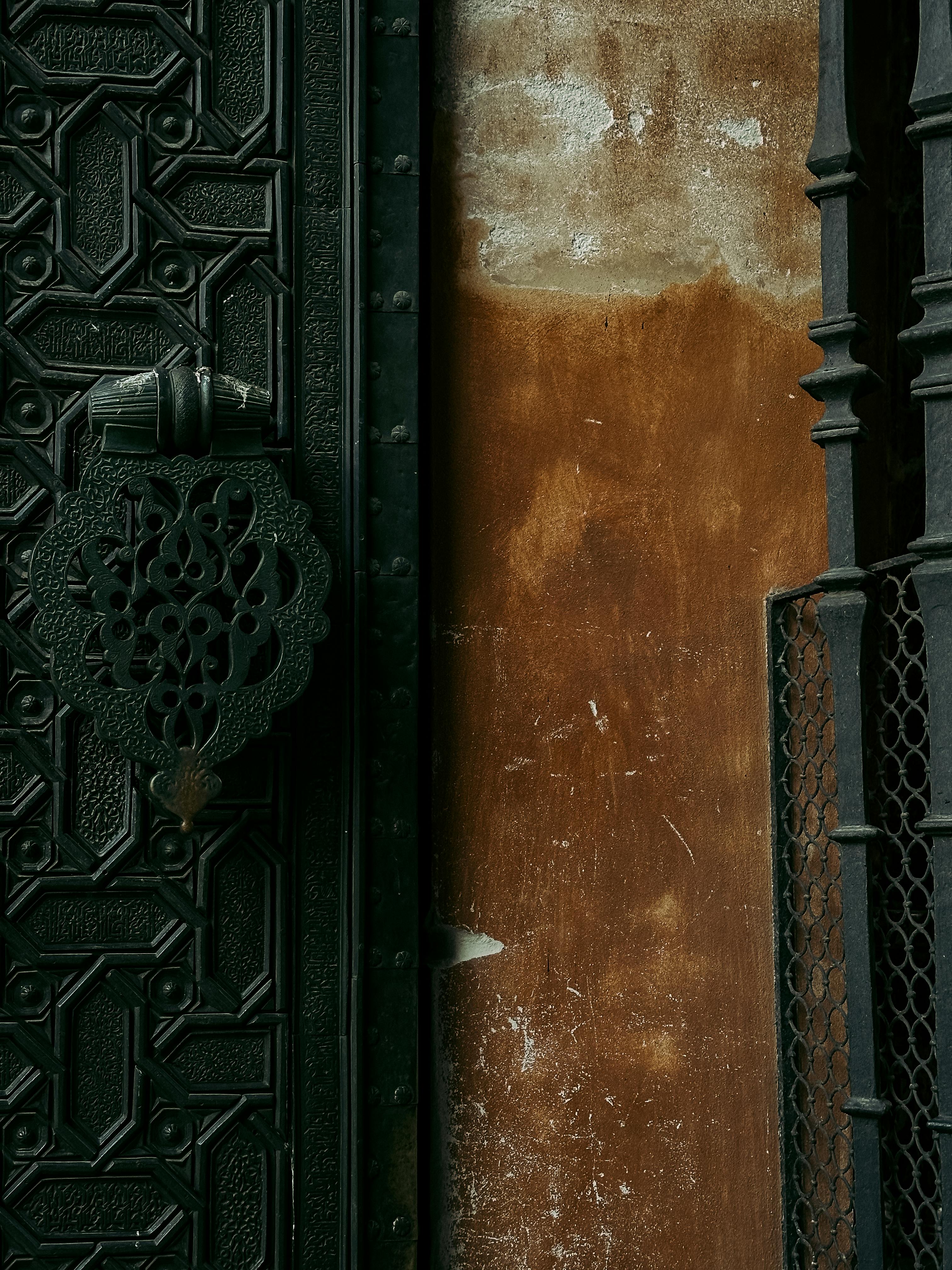 免费 塞维利亚华丽的铁门和纹理丰富的墙壁，展现了安达卢西亚建筑的优雅。 素材图片