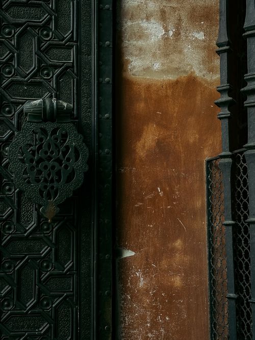 Free Ornate iron door and textured wall in Seville, showcasing Andalusian architectural elegance. Stock Photo