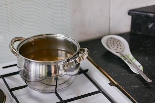 A stainless steel pot on a stove in a contemporary kitchen setting.