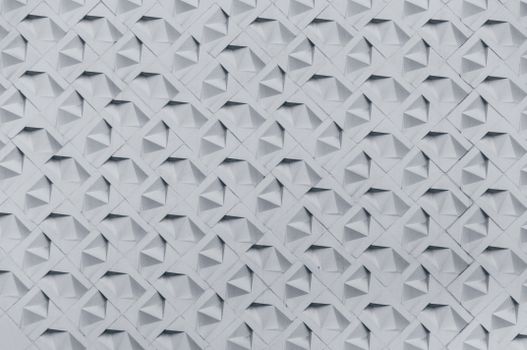 Textured wall showcasing a geometric 3D pattern in monochrome tones, perfect for architectural inspiration.