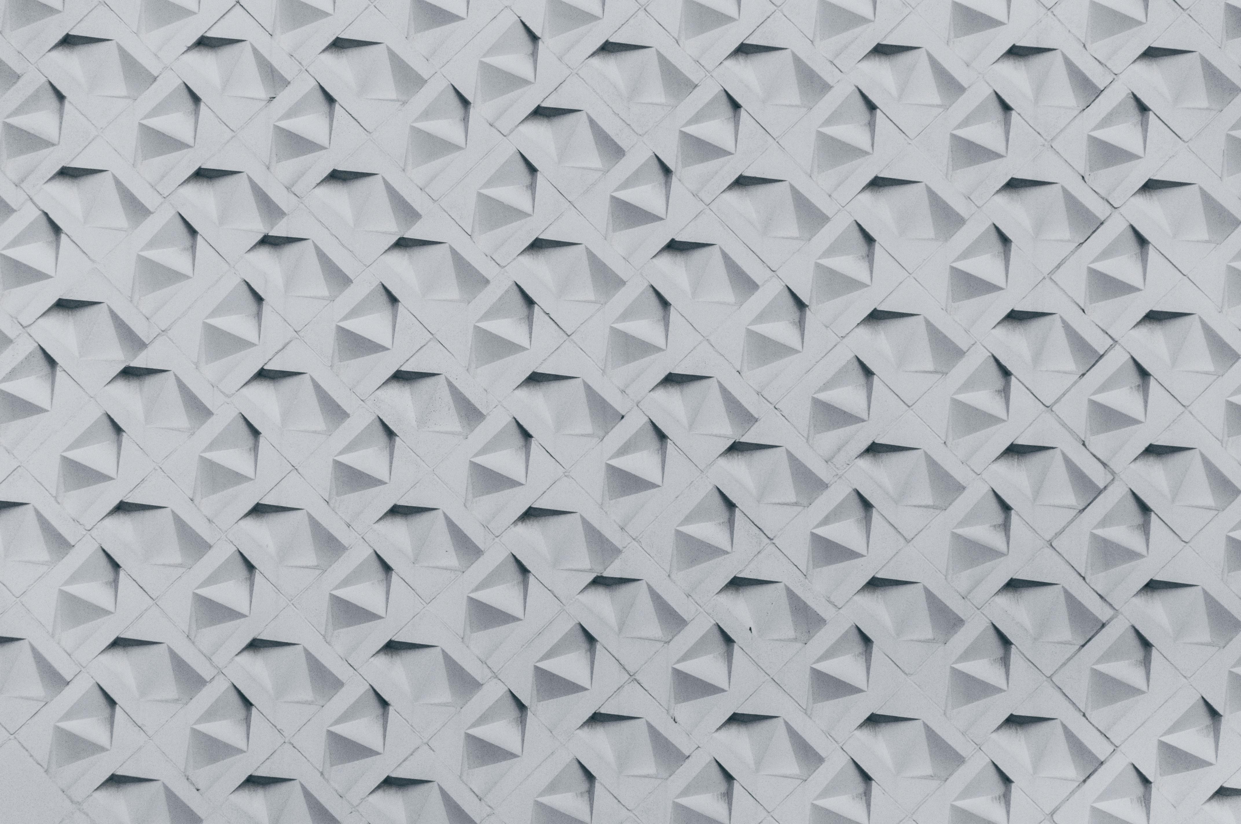 Bezpłatne Teksturowana ściana prezentująca geometryczny wzór 3D w monochromatycznych odcieniach, idealna dla inspiracji architektonicznych. Zdjęcie z galerii