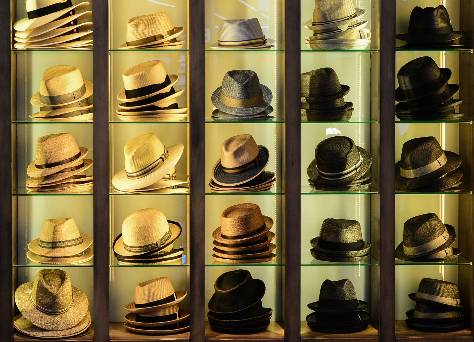 A collection of fashionable hats displayed on retail shelving in a headwear store