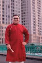 Man in Red Traditional Attire in Urban Setting