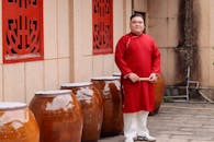 Man in Red Traditional Robe by Ceramic Jars
