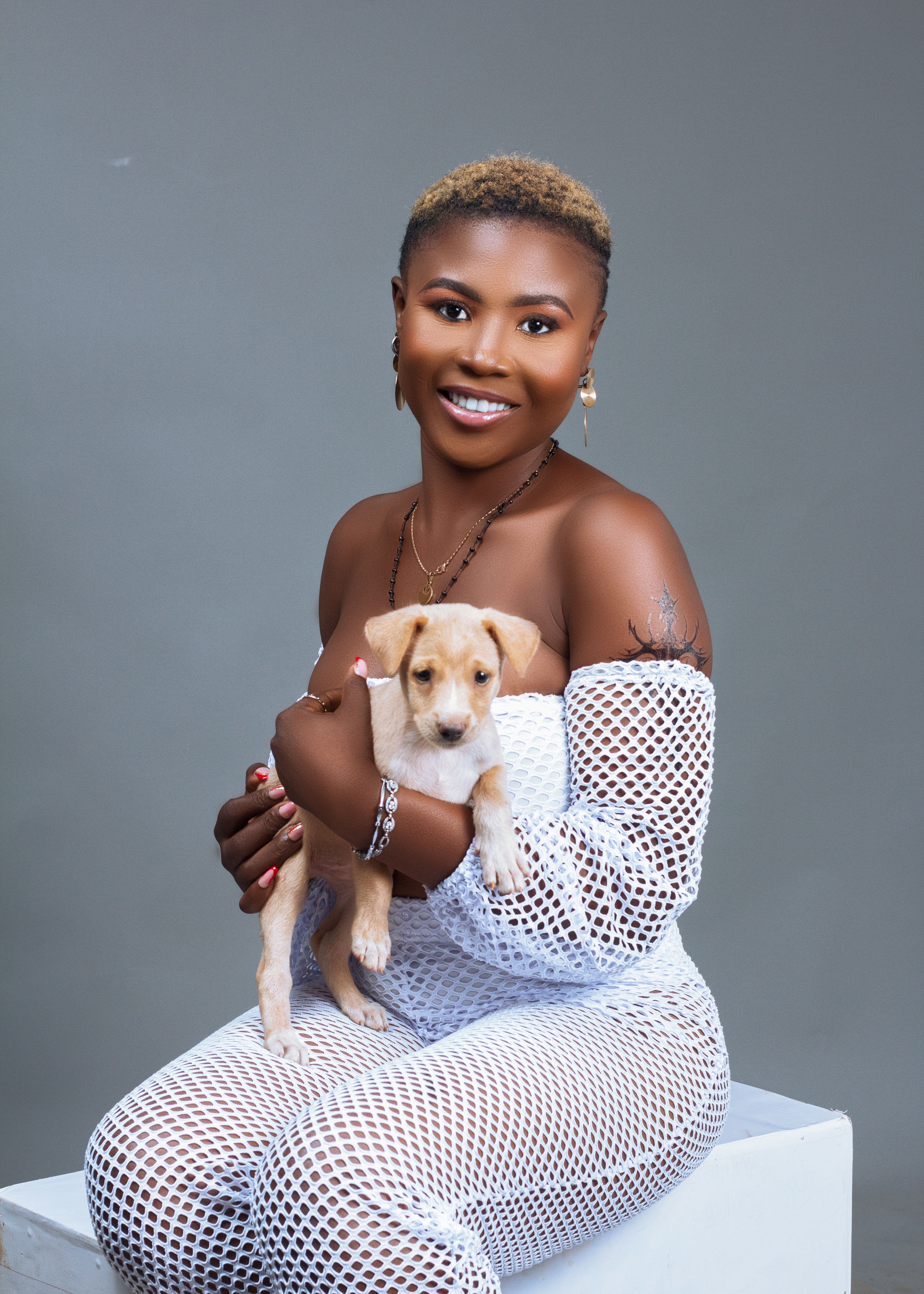 Charming portrait of a woman holding a puppy in a studio setting. Perfect for lifestyle themes.
