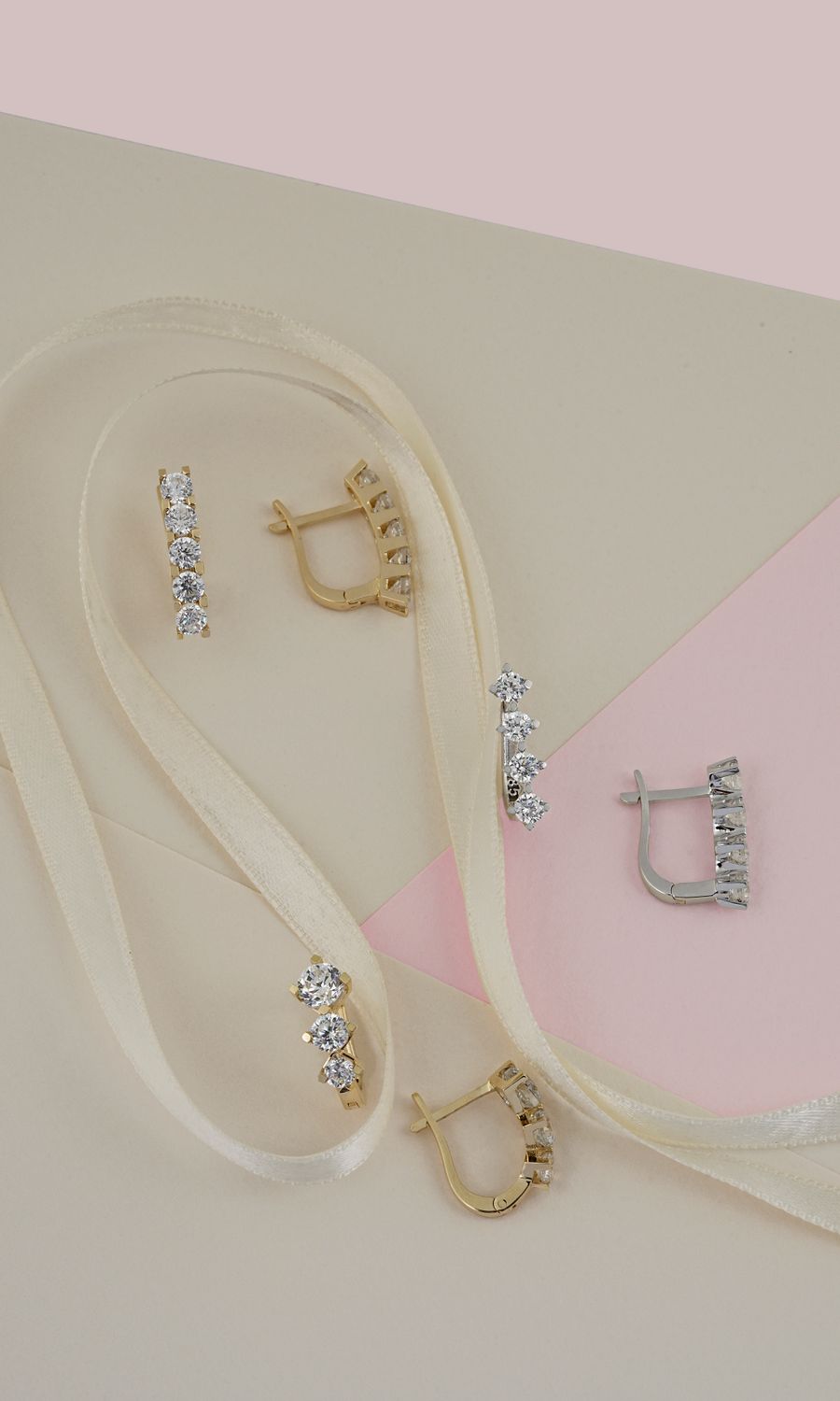 Gold and silver earrings with diamonds on pastel paper