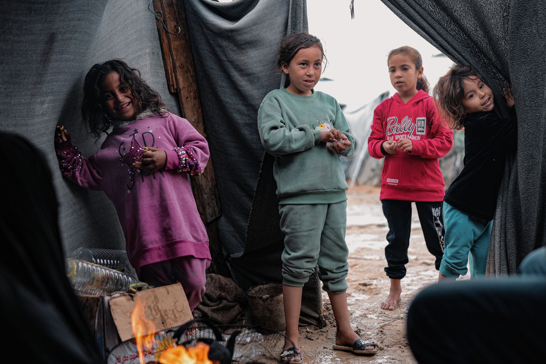 Four children playing near tents in a refugee camp in Gaza, depicting resilience and hope.