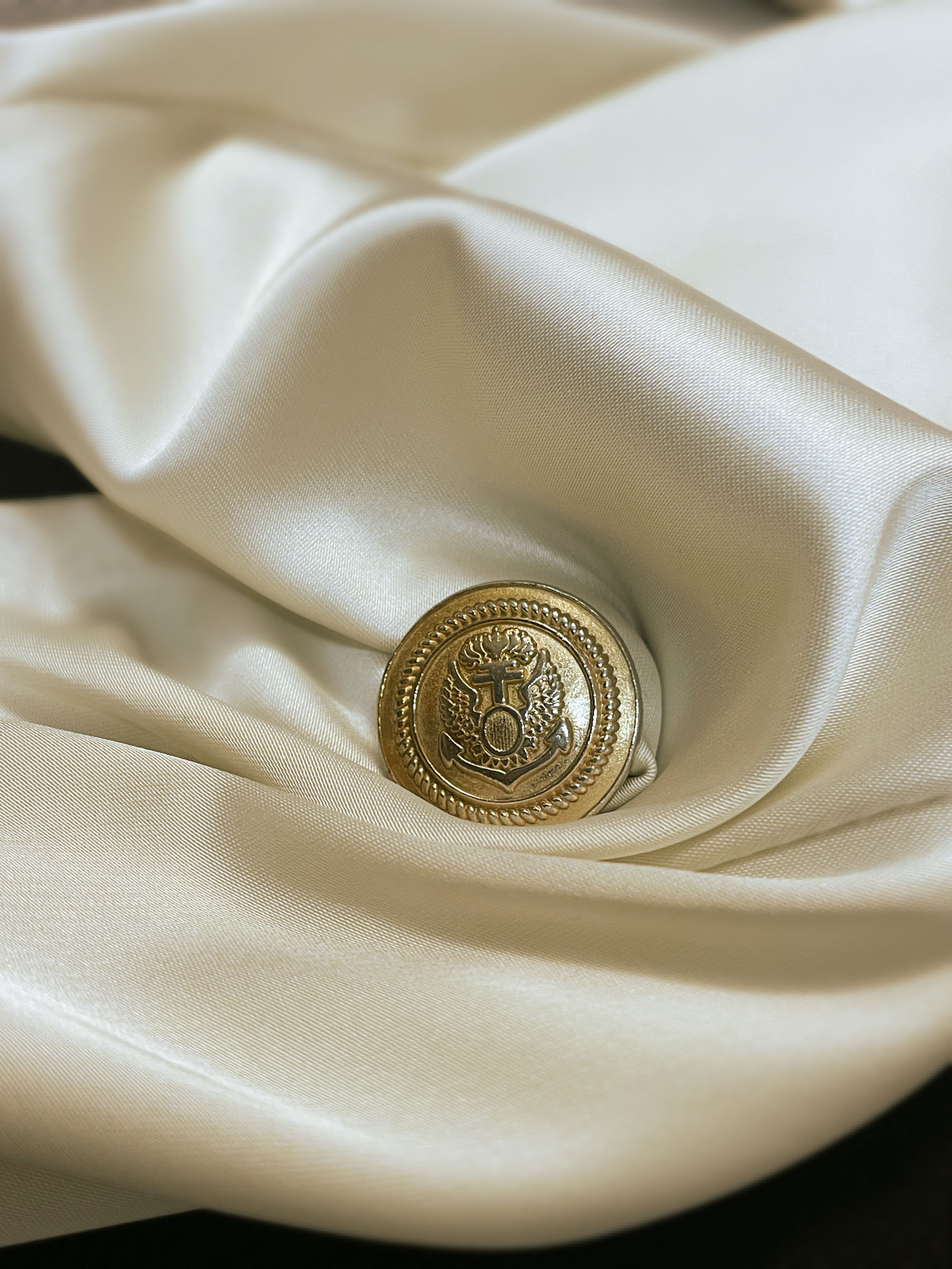 Elegant Gold Button on Luxurious Fabric · Free Stock Photo
