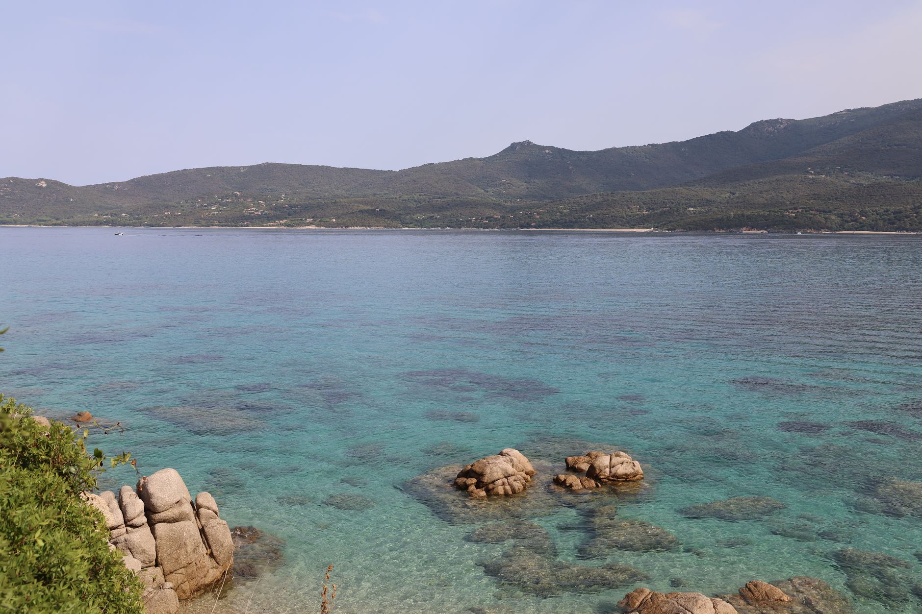 Stunning coastal landscape showcasing clear turquoise waters against a mountainous backdrop.