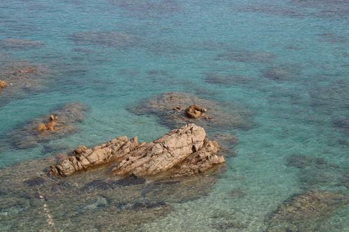 Free Aerial view of a turquoise sea with rocky outcrops, showcasing serene waters. Stock Photo