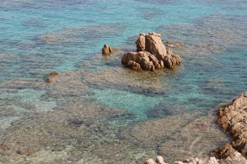 Free Vibrant turquoise sea with rocky formations, showcasing clear water and natural beauty. Stock Photo