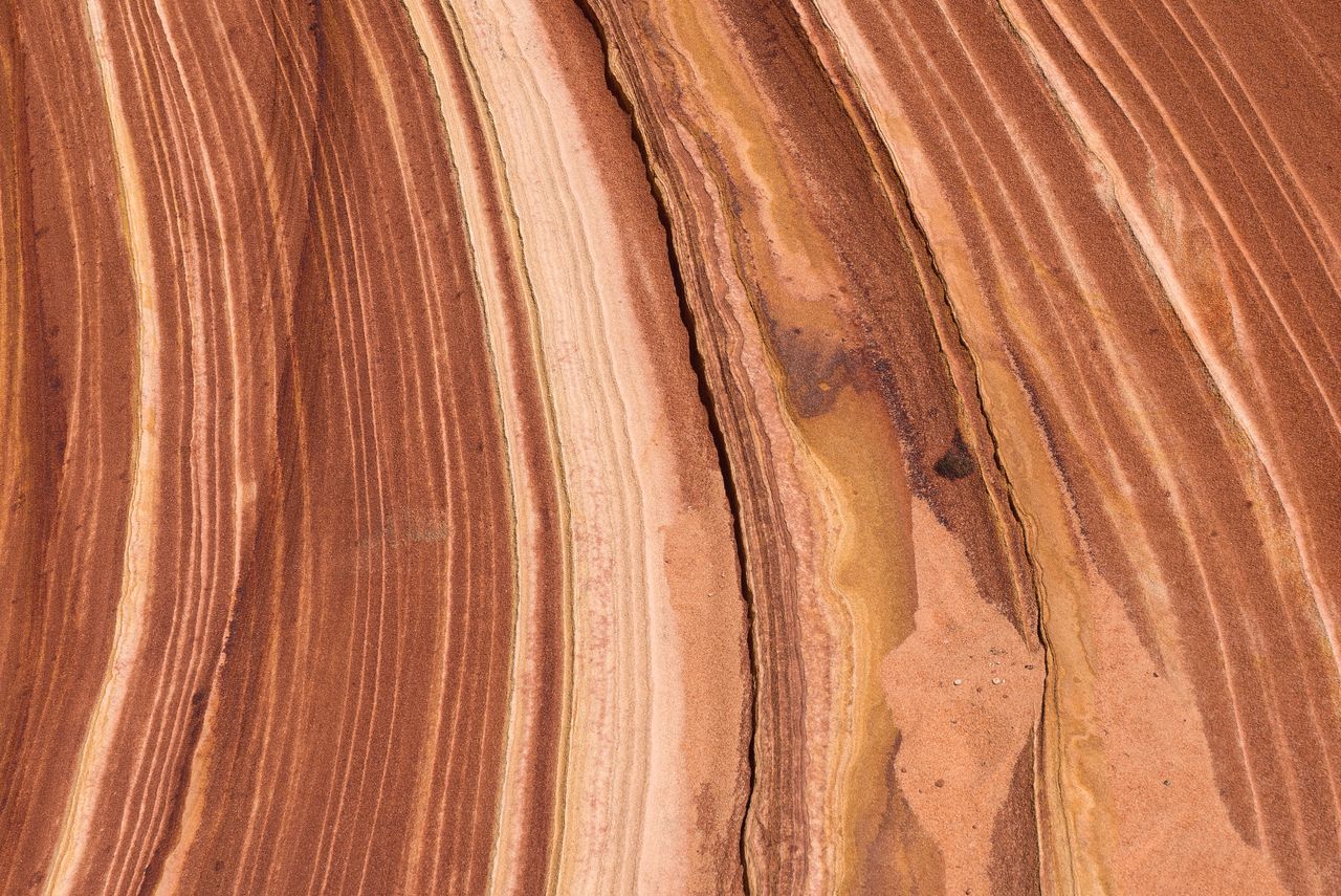 close up of a sandstone surface showcasing unique striations and earth
