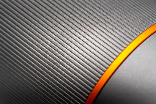 Close-up of a sleek metallic texture with an orange accent, ideal for industrial design concepts.