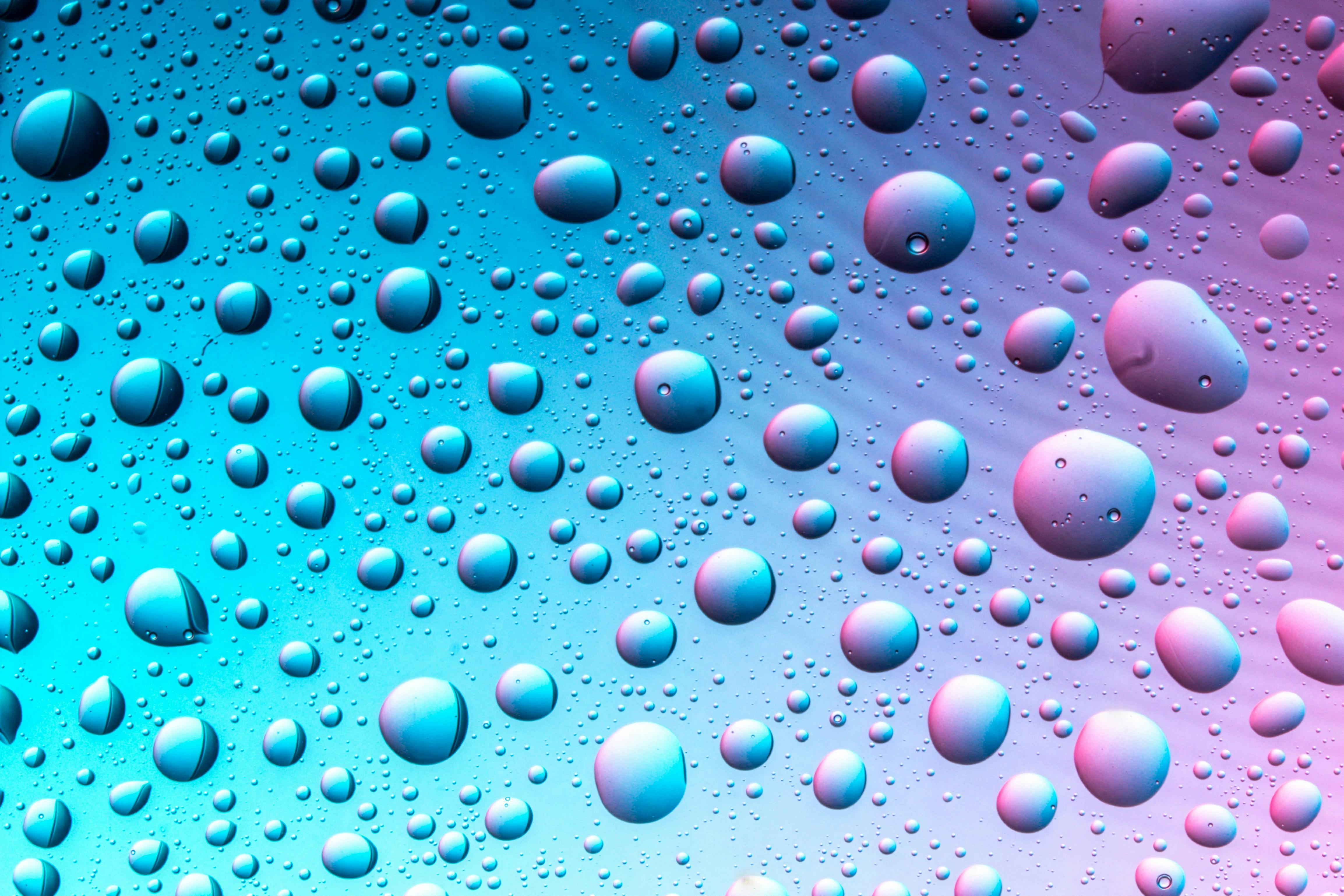 Δωρεάν Αφηρημένη εικόνα σταγονιδίων νερού σε μπλε και ροζ φόντο με διαβάθμιση, δημιουργώντας μια ζωντανή και μοντέρνα εμφάνιση. Φωτογραφία από στοκ φωτογραφιών