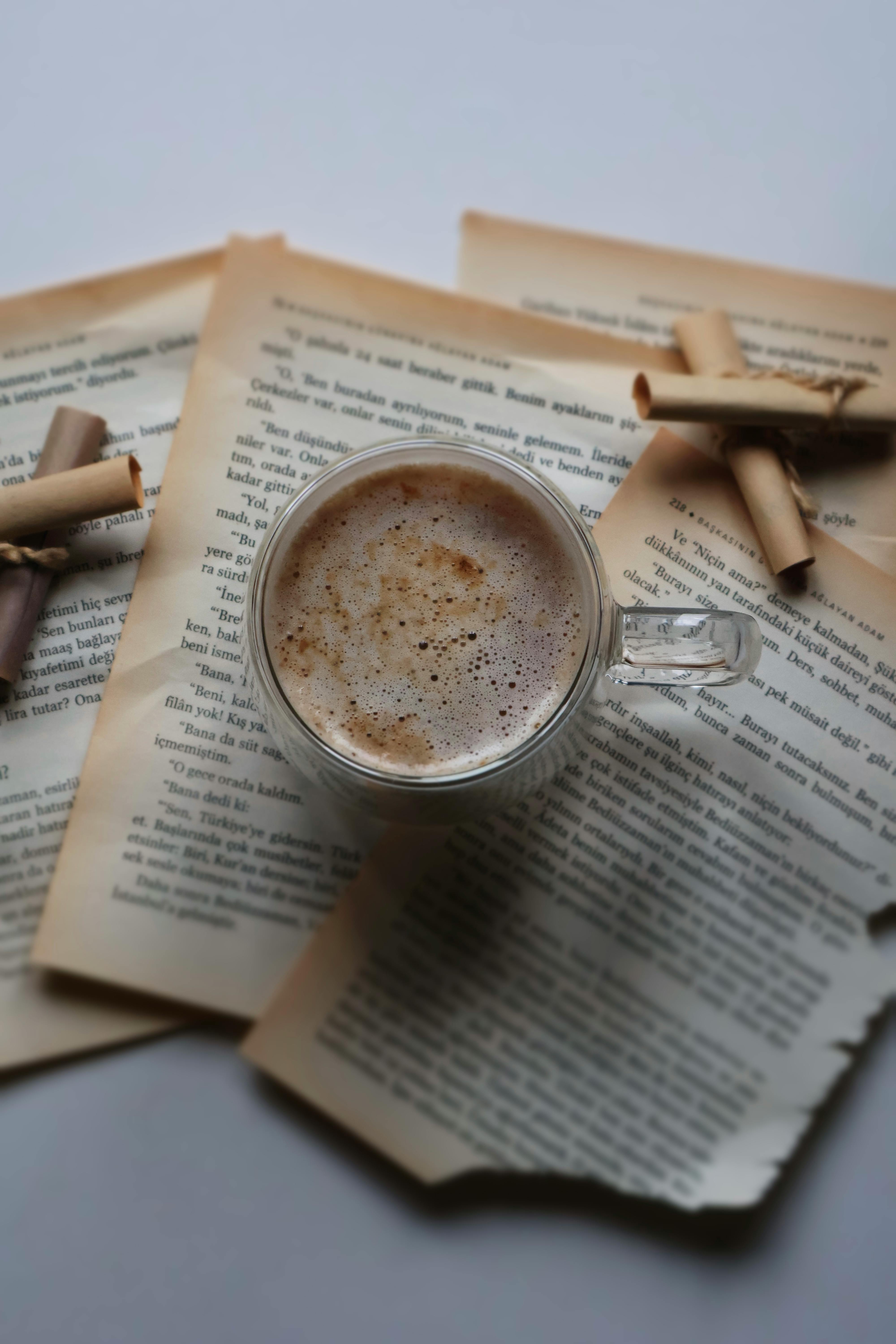 A warm coffee mug resting on aged book pages, creating a nostalgic and cozy scene.