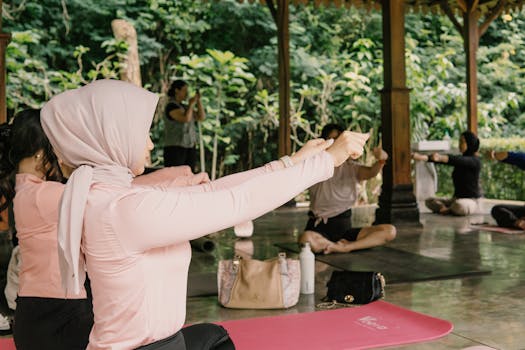 Women practicing yoga outdoors in a serene pavilion setting in Indonesia.