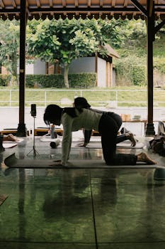 Group yoga class in open-air pavilion in Indonesia, focusing on wellness and tranquility.