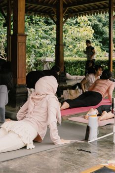 A relaxed outdoor yoga class in a serene setting in Jawa Barat, Indonesia.