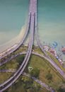 从空中俯瞰，一个充满活力的水道上方，复杂的公路和桥梁网络纵横交错，四周环绕着绿色空间