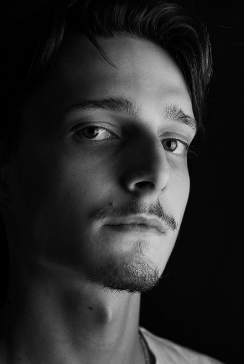 Free Monochrome close-up portrait of a young male with intense expression, classic lighting. Stock Photo