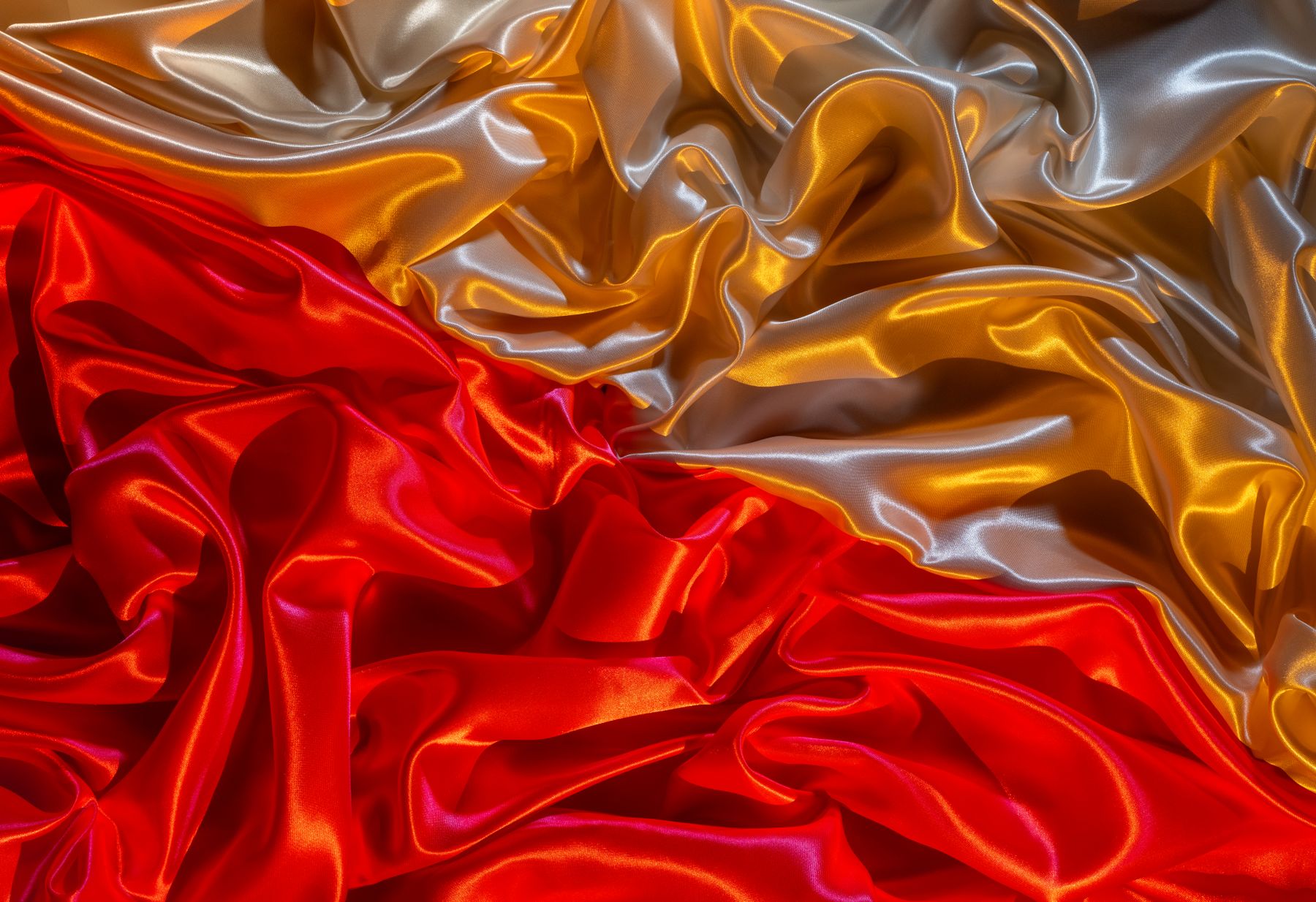 Crimson and gold silk folded into molten ridges — photo by Rafael Minguet Delgado on Pexels