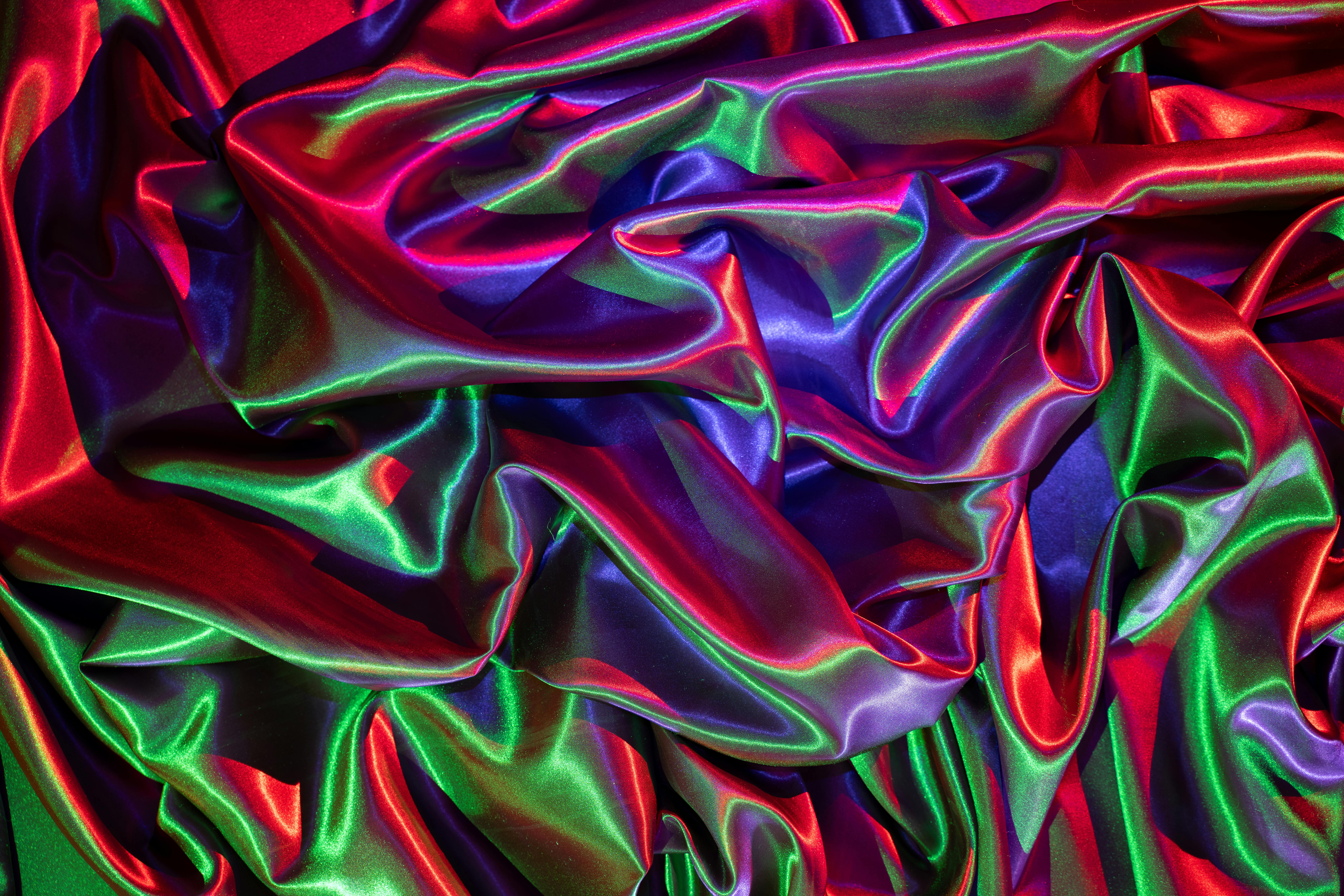 gratis Kleurrijke plooien van satijnstof in rood, groen en blauw creëren een levendige, abstracte textuur. Stockfoto