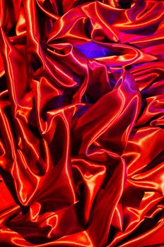 Eye-catching image of red satin fabric folds enhanced by creative lighting, showcasing vibrant colors and texture.