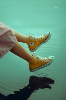 黄色运动鞋在平静的水面上荡起涟漪，尽显休闲与时尚