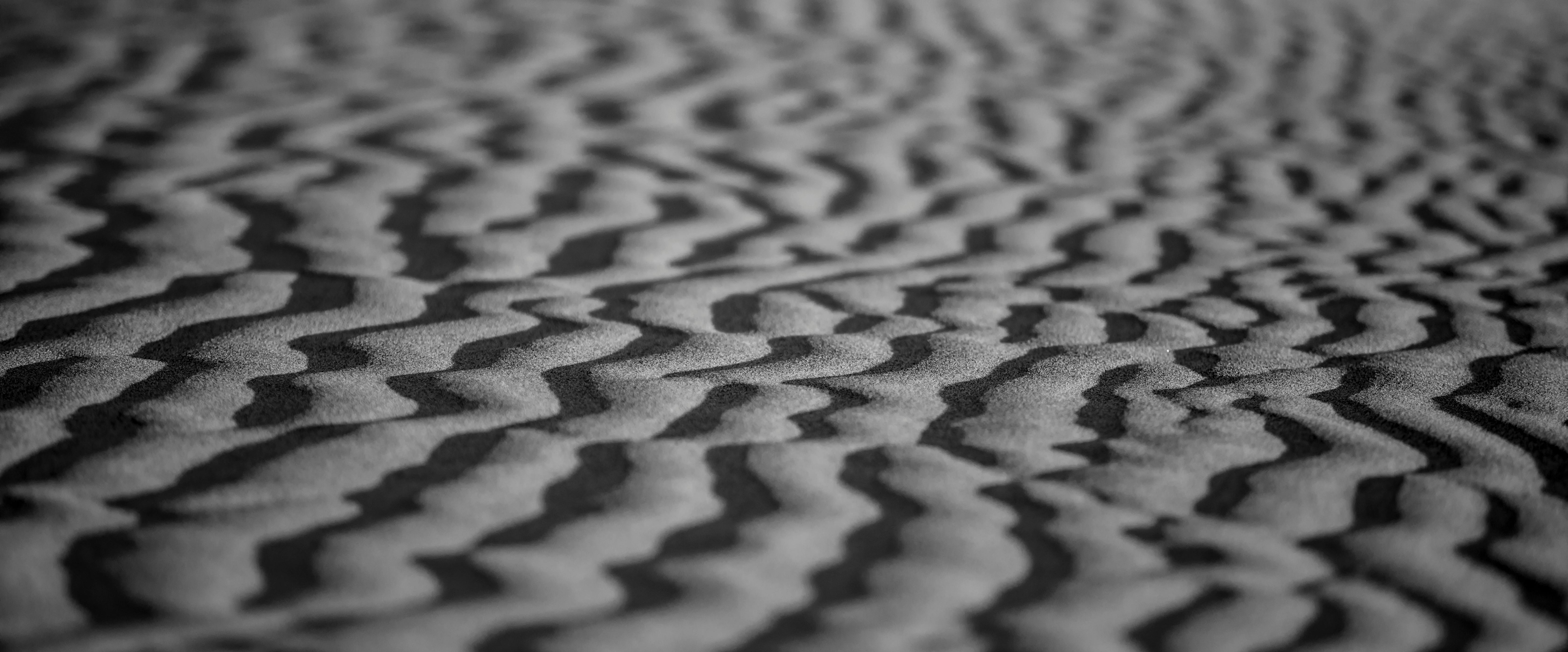 Gratuit Gros plan monochrome de motifs de sable désertique sculptés par le vent, avec un flou artistique. Photos