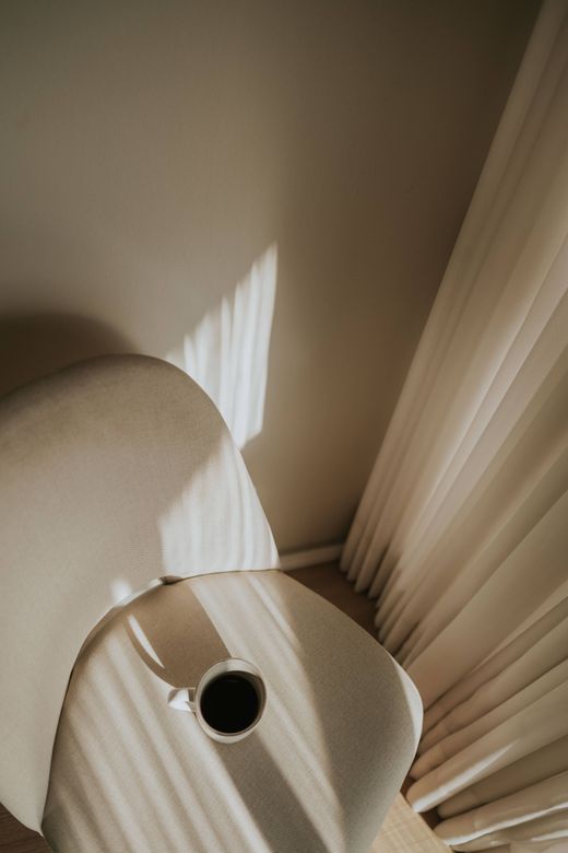 Sunlight over a pale curved chair — photo by Let&iacute;cia Alvares on Pexels