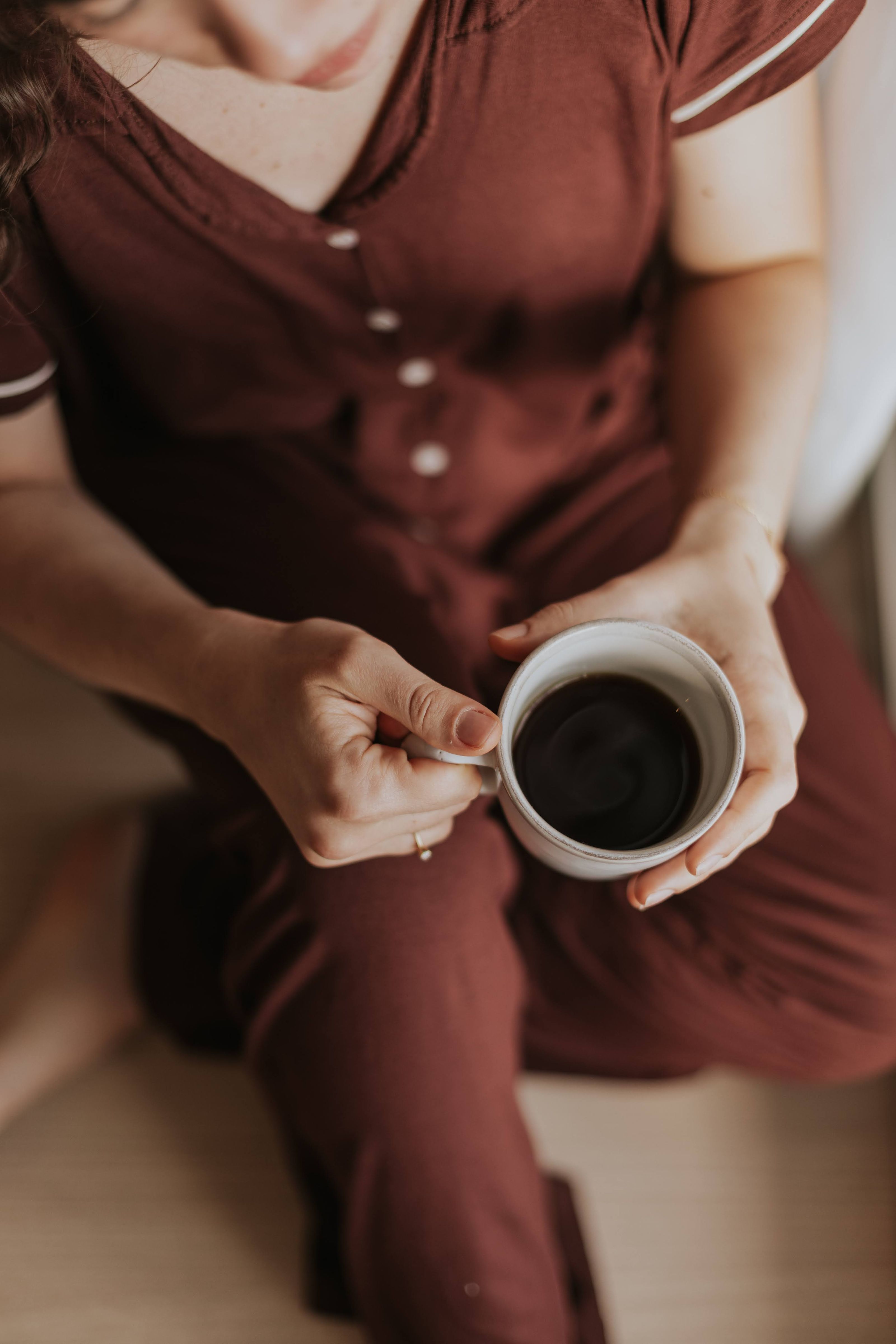 Um adulto desfrutando de um momento de paz com uma xícara de café em um ambiente interno com luz suave.