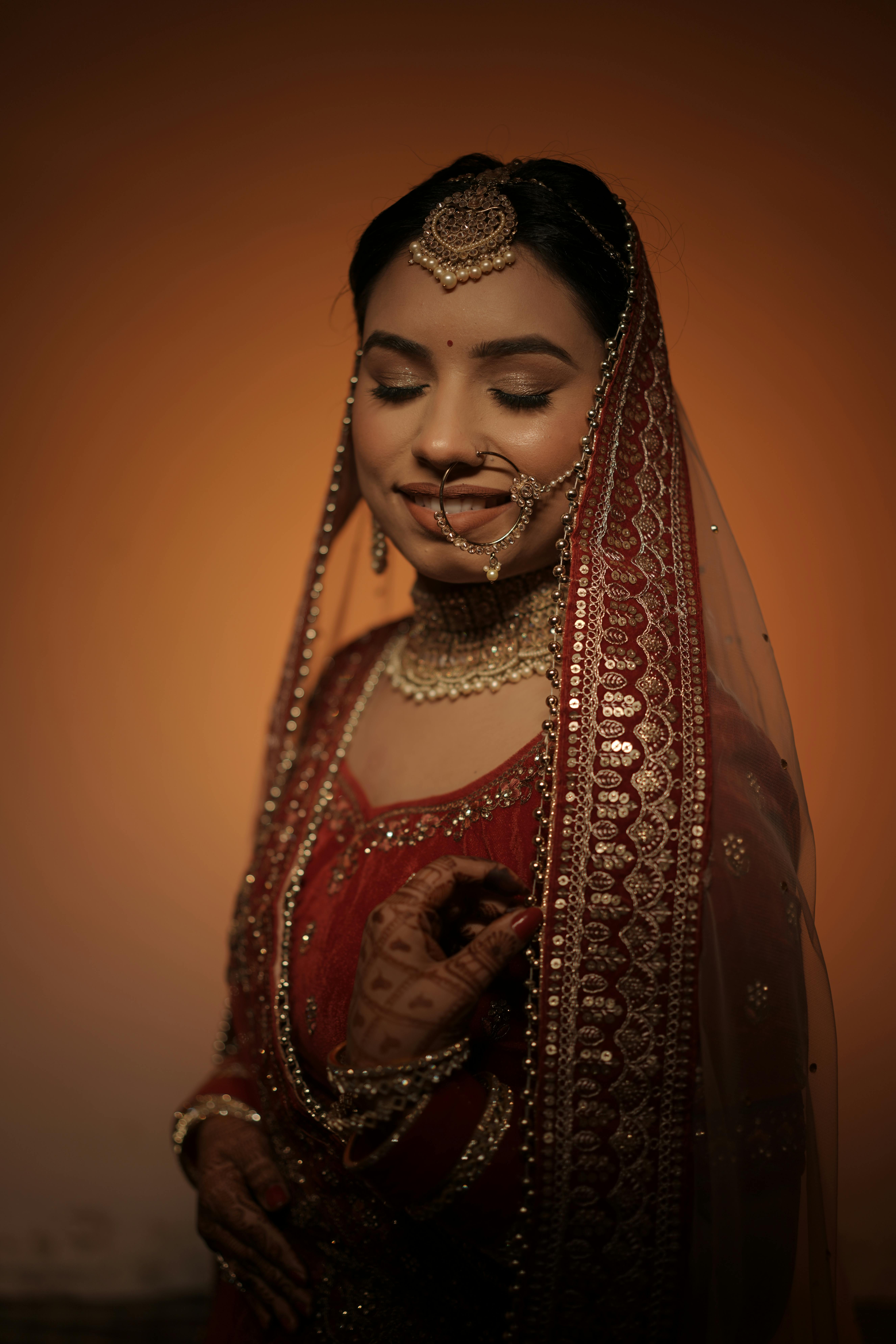Beautiful Indian bride wearing traditional red bridal attire with intricate jewelry.