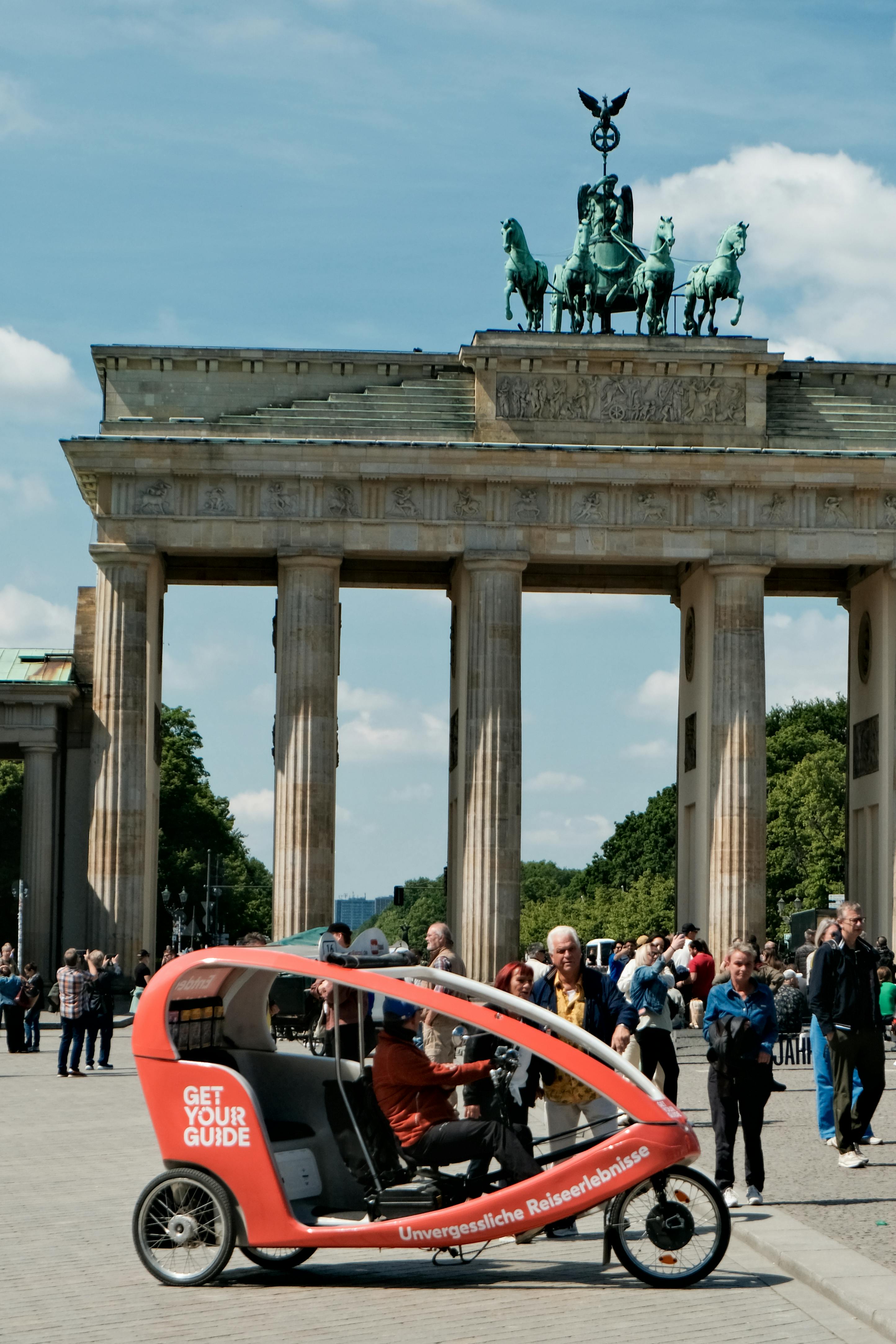 Tourists gather at the iconic Brandenburg Gate in Berlin, a popular sightseeing spot.