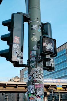 Traffic light in Berlin adorned with eclectic stickers, capturing urban street art vibe.
