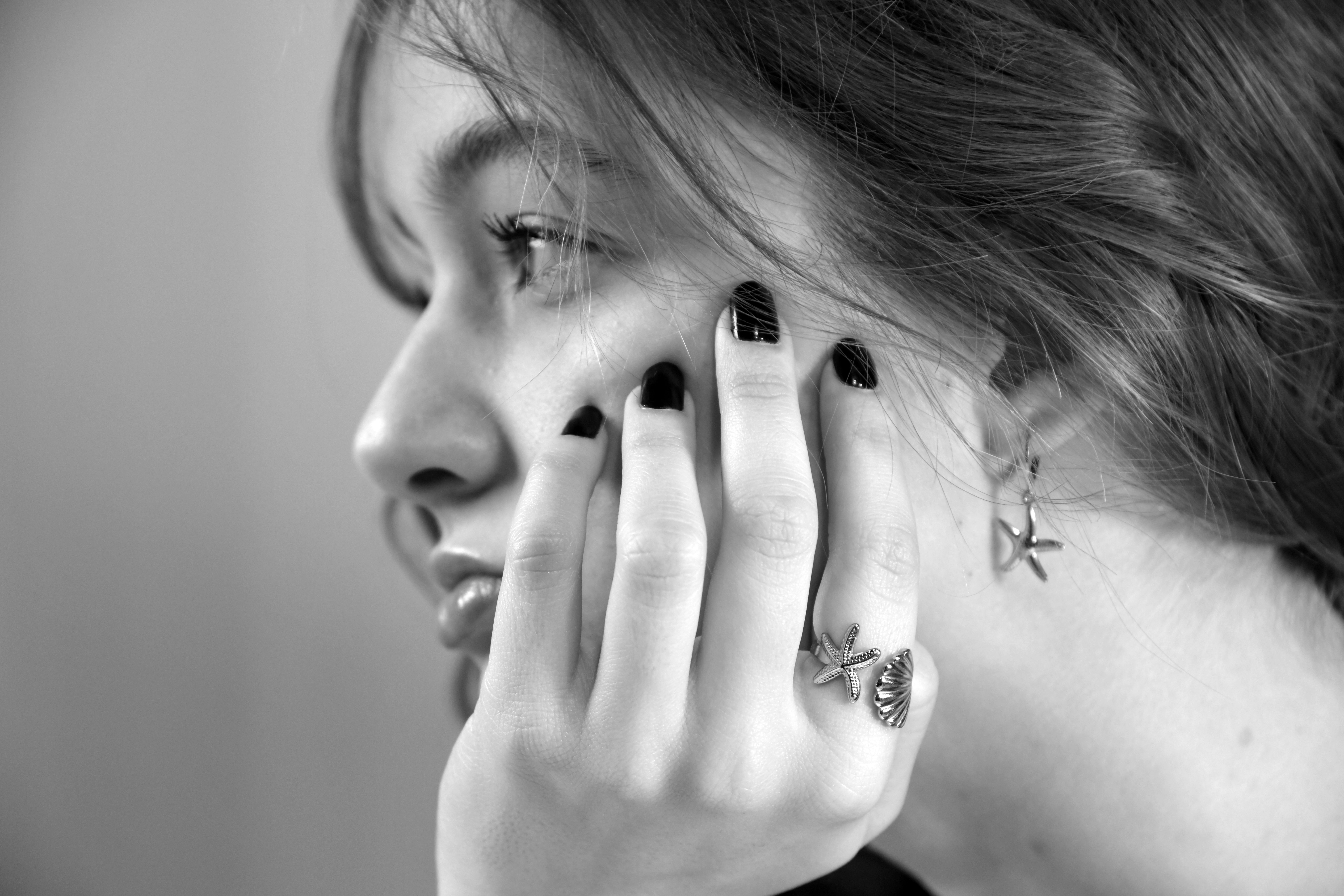 Gratis Elegante profilo laterale in bianco e nero di una donna con accessori a tema stella marina. Foto a disposizione