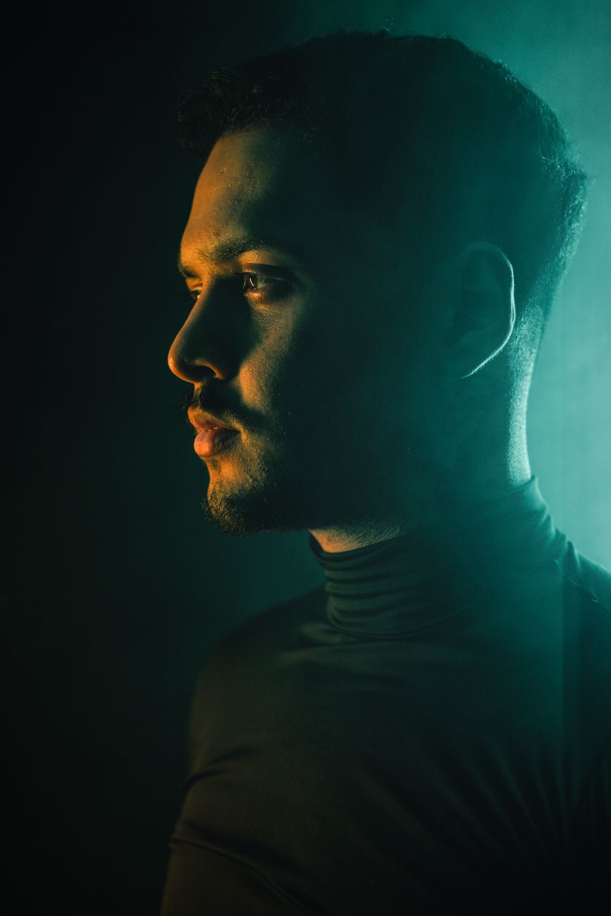 Side profile portrait of a man with dramatic lighting creating a moody atmosphere.. side, profile, portrait