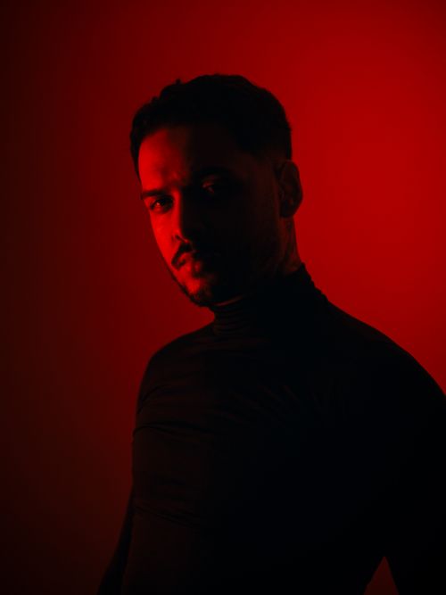 Free Dramatic portrait of a man in red lighting creating a mysterious and intense mood. Stock Photo