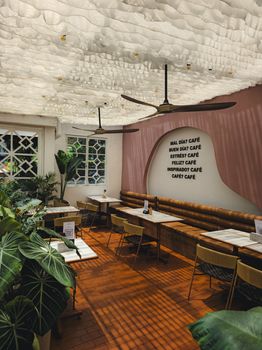 Bright Bucaramanga cafe featuring modern decor, plush seating, and lush plants.
