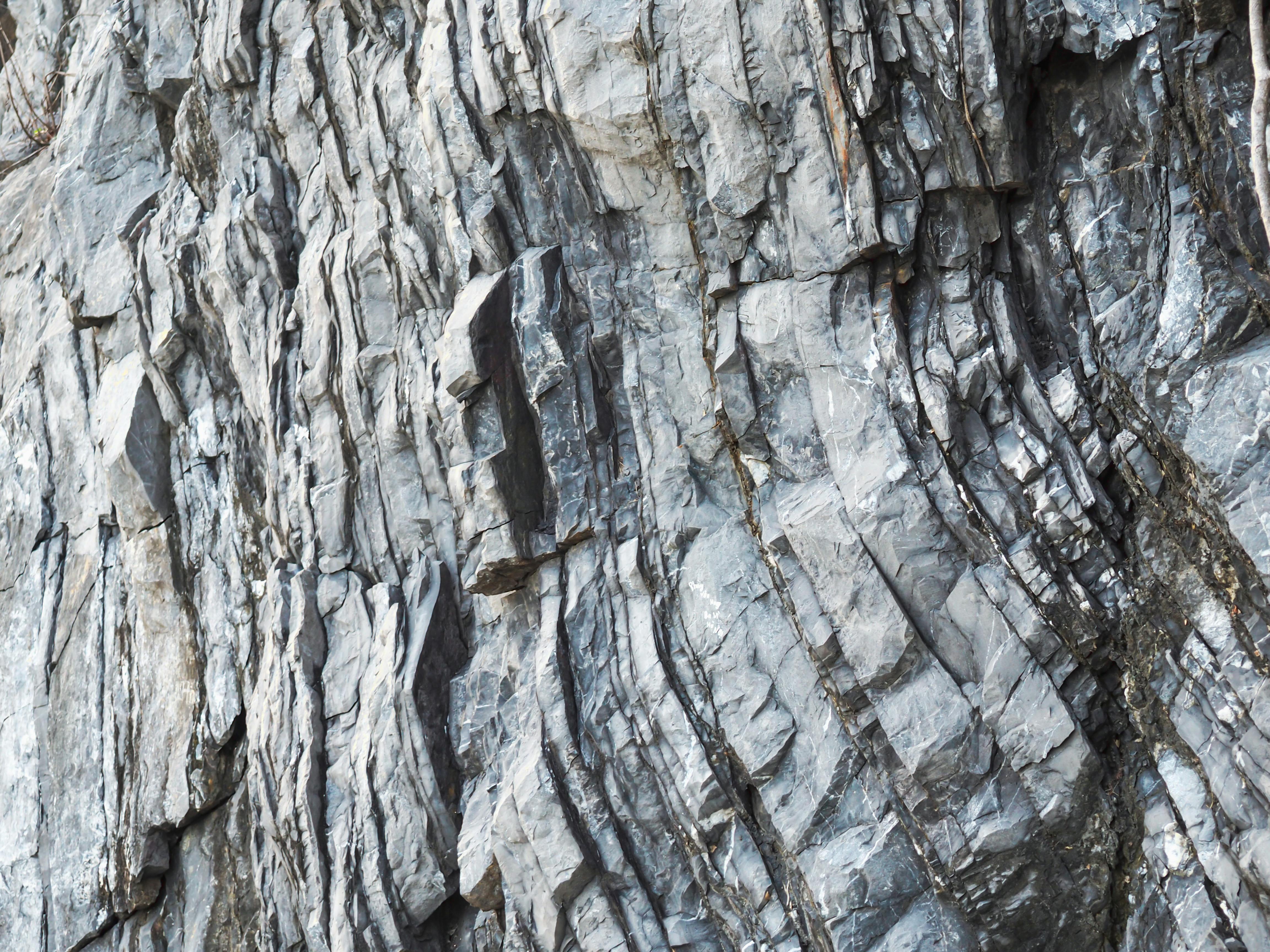 Безкоштовне Детальний крупний план шаруватих скельних утворень, що демонструють природні геологічні закономірності. стокове фото