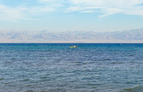 Free Discover tranquility while kayaking with stunning mountainous backdrop on the Red Sea. Stock Photo