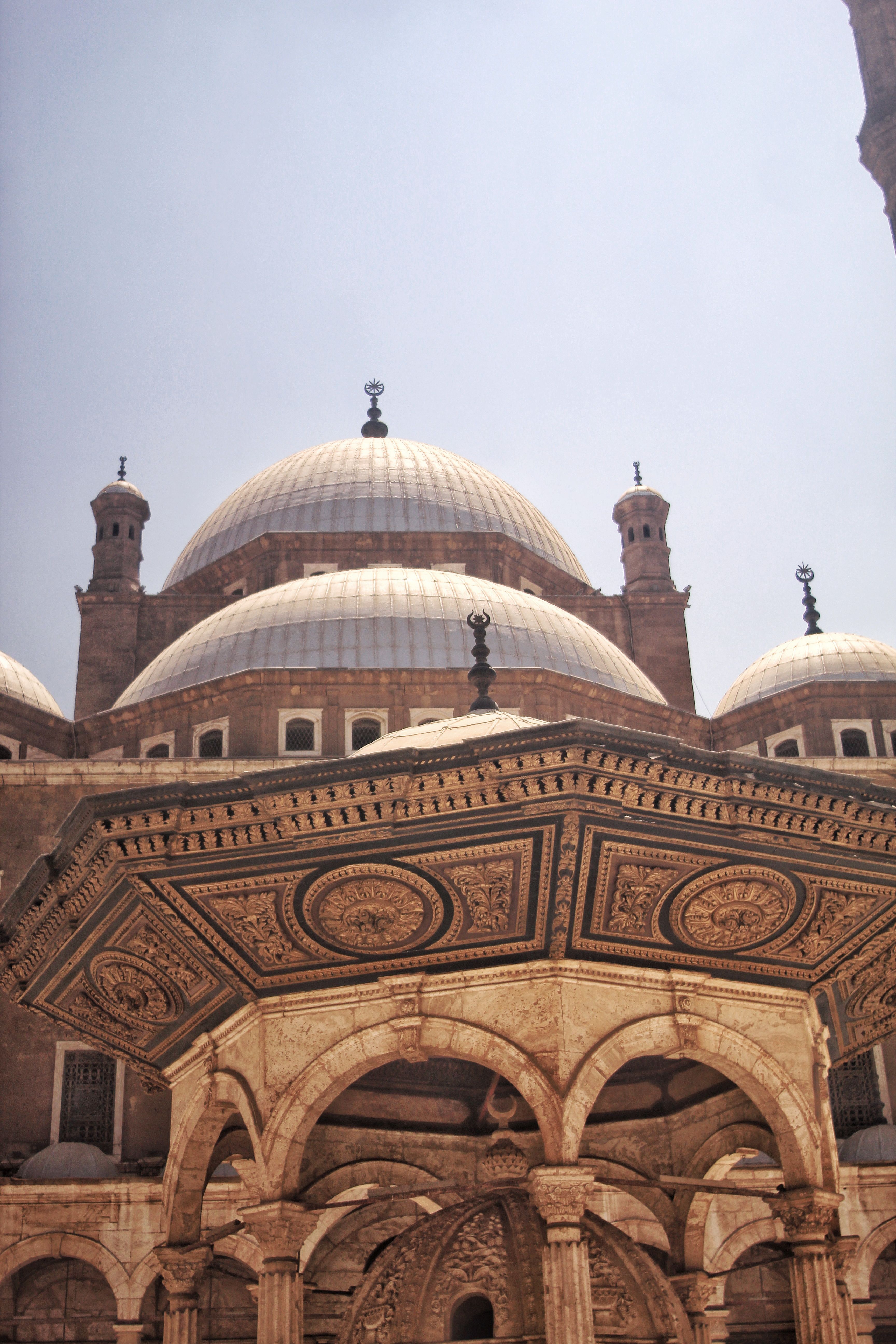 Historic Mosque of Muhammad Ali with stunning domes and intricate designs under a clear sky.