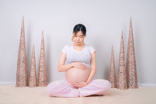 Woman Showing Her Baby Bump While Sitting on Floor
